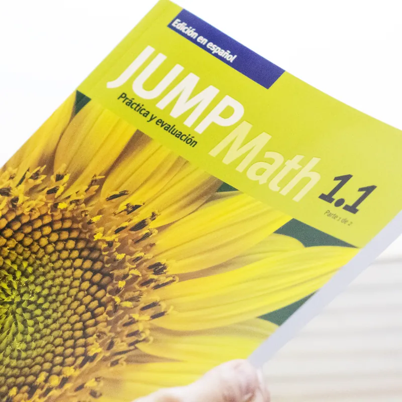 Persona sosteniendo el libro de práctica y evaluación JUMP Math 1.1